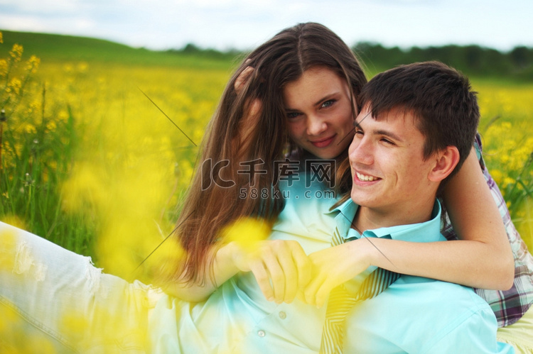 情人拥抱在黄色的花田