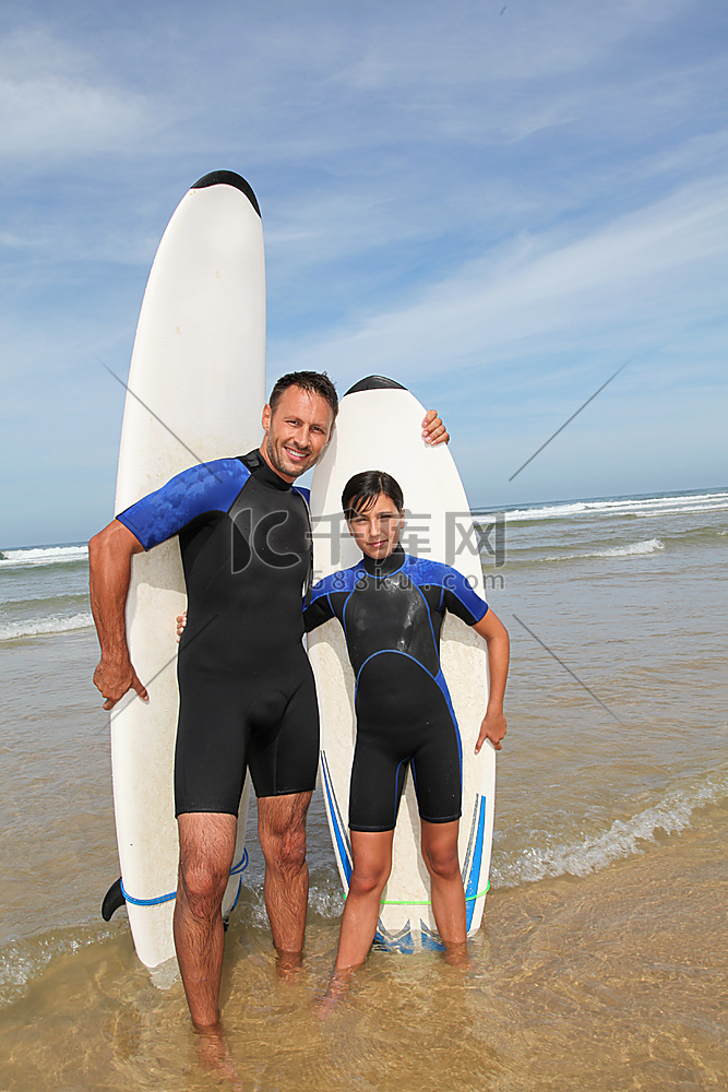 父亲和女儿在海洋冲浪