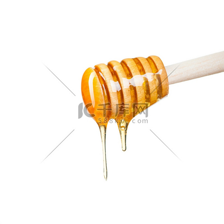 在白色背景下，蜂蜜从勺子里滴出