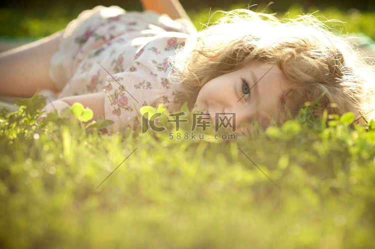 阳光下，一个漂亮的孩子躺在春天