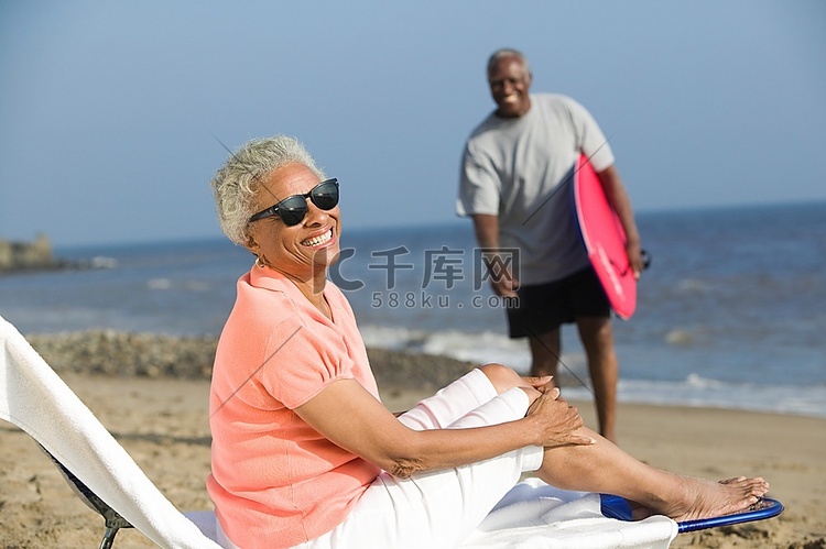 坐在沙滩躺椅上的中年妇女