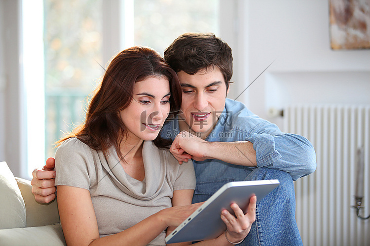 年轻夫妇在家中使用电子平板电脑