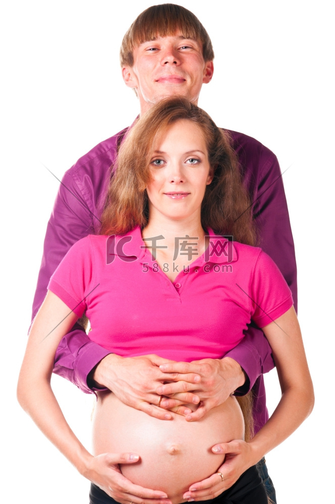 一名男子在白色背景下拥抱一名孕