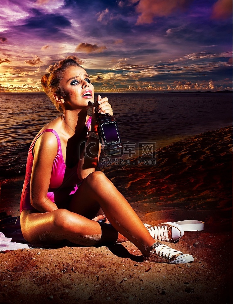 美丽的年轻女子在海滩上喝酒-酗