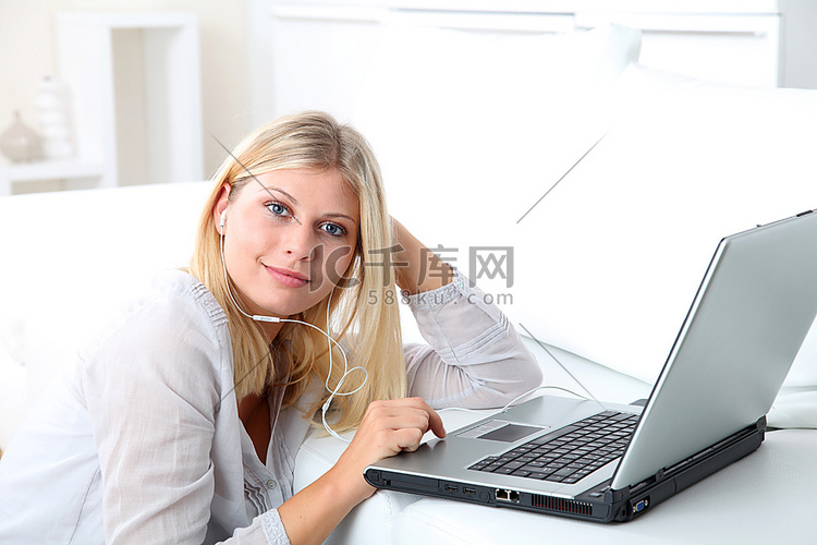 美丽的金发女子在笔记本电脑前戴