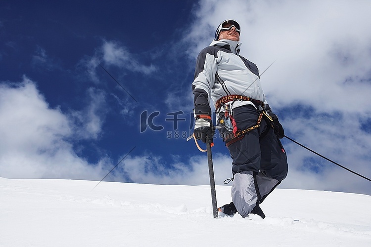 登山者站在雪坡上，系上安全线