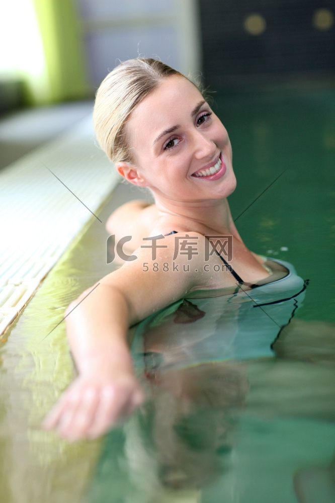 美丽的金发女子在温泉浴池中放松
