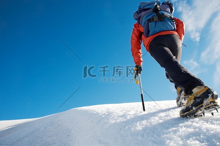 孤独的男性登山者攀登白雪覆盖的