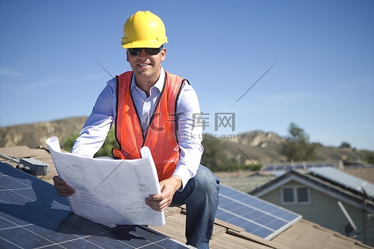 一位商人站在太阳能屋顶上看着平