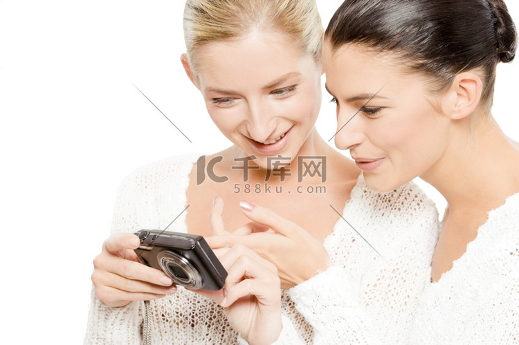 两名年轻女子在数码相机上看照片