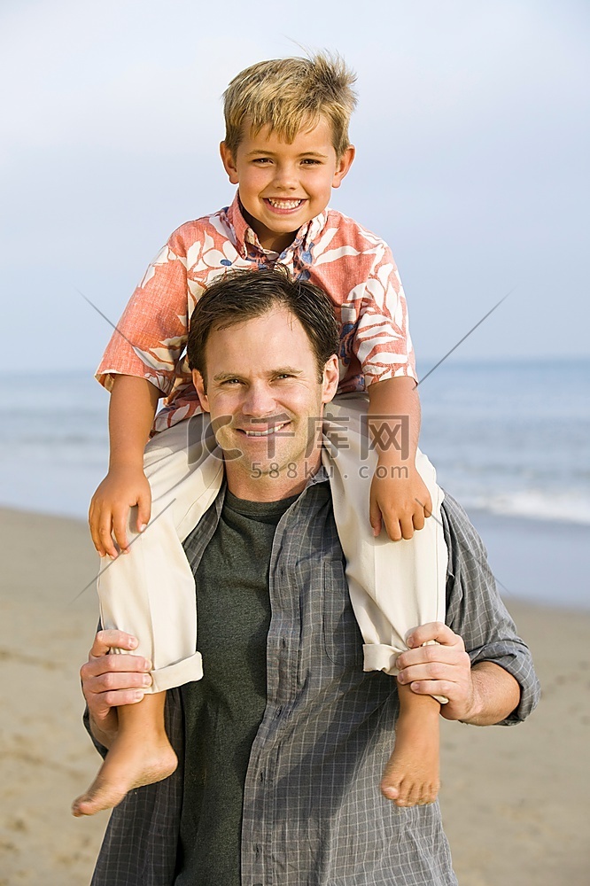 海滩上父亲肩上的男孩肖像