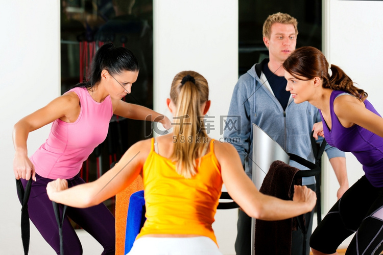 健身房里的女性和教练在健身机前