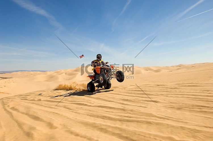 骑着亚视飞过沙丘的年轻人