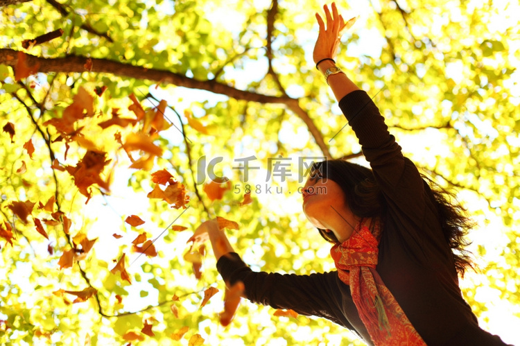 女人掉叶子在秋天公园