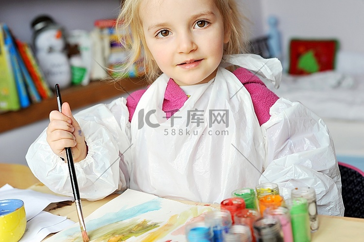漂亮的小女孩在纸上用水粉作画