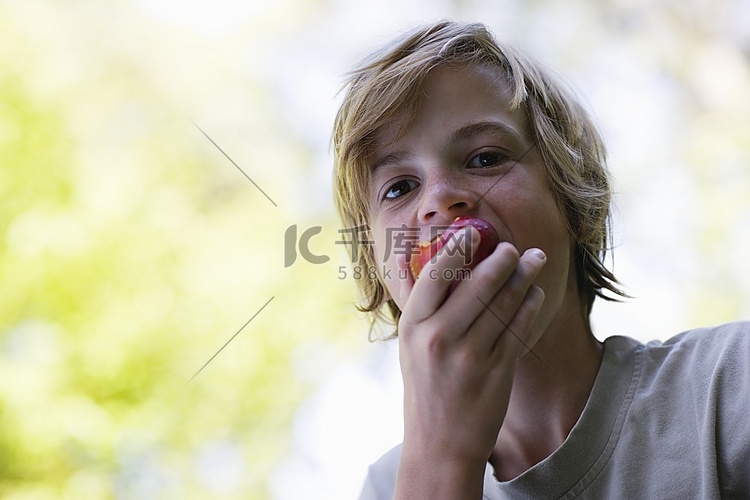 男孩(10-12岁)吃苹果的肖像