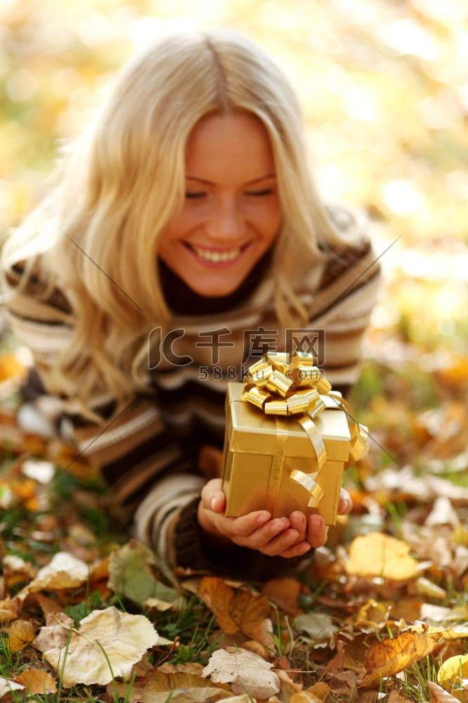 一名女子在公园里接受秋天的礼物