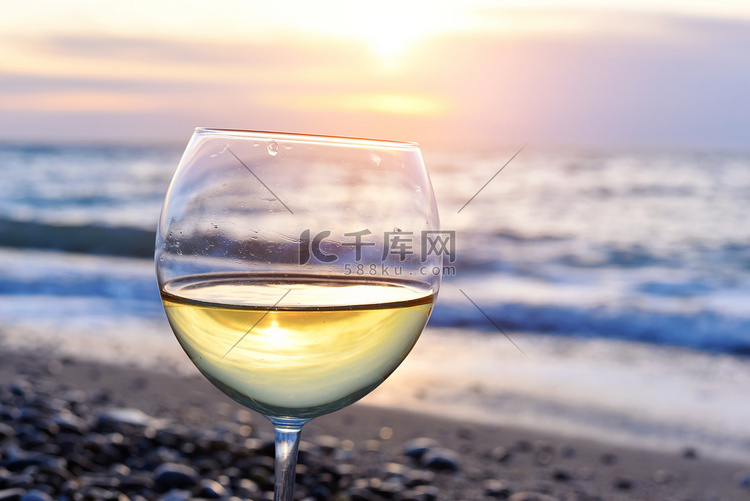 浪漫 glass 的酒坐在沙滩
