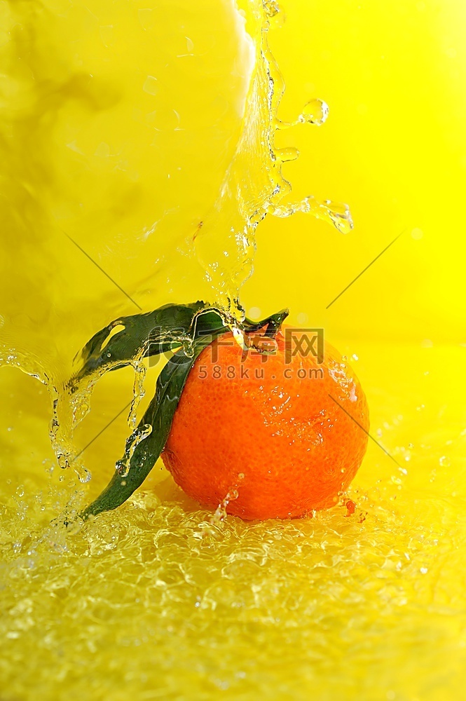 橘子和水溅在黄色上的特写