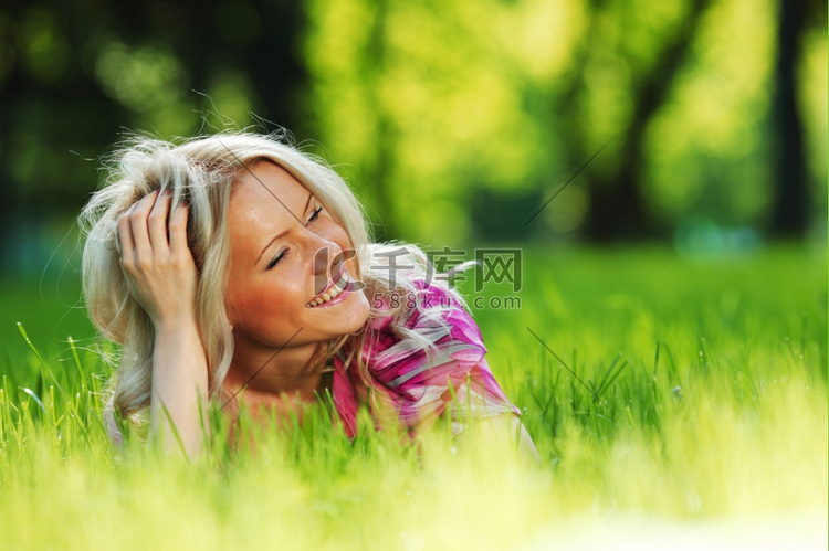 躺在绿草地上的金发女郎