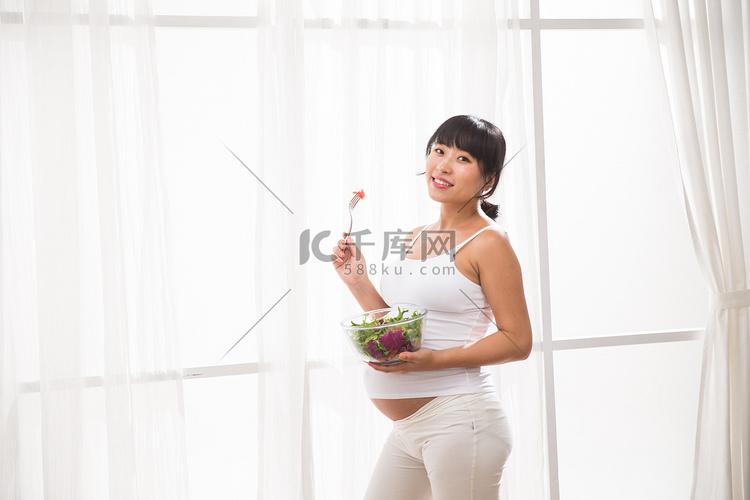 幸福的孕妇吃蔬菜沙拉