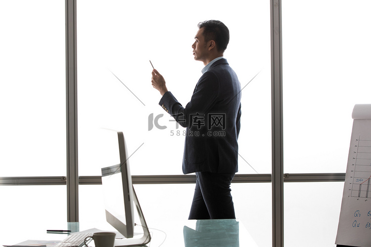 商务男士在窗户前看手机