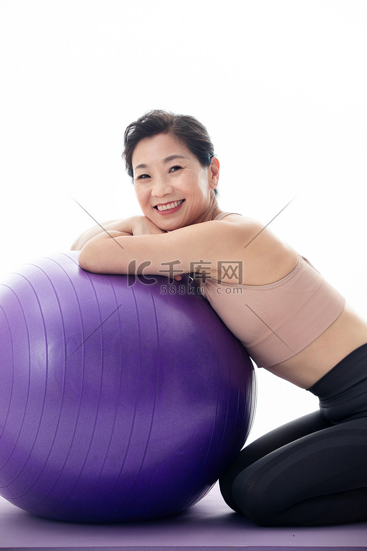 趴在瑜伽球上的中年女人