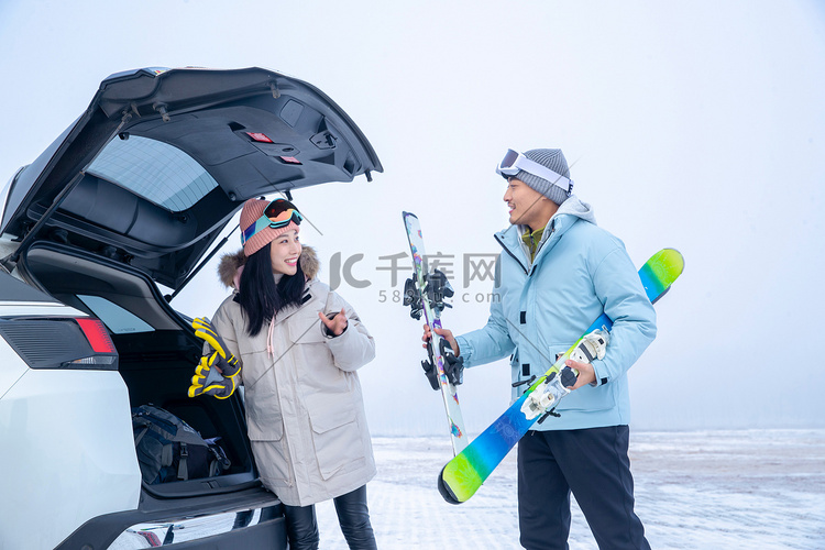 滑完雪的青年伴侣往汽车后备箱里