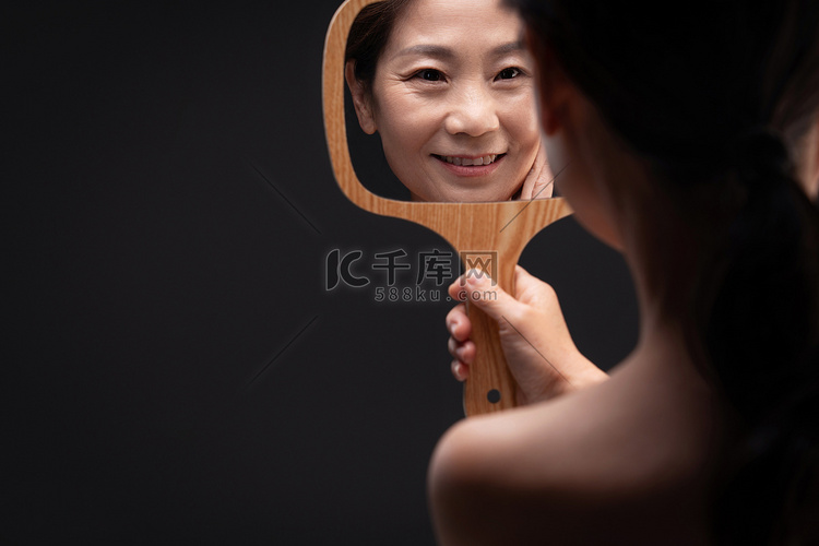 拿着镜子照的中年女人