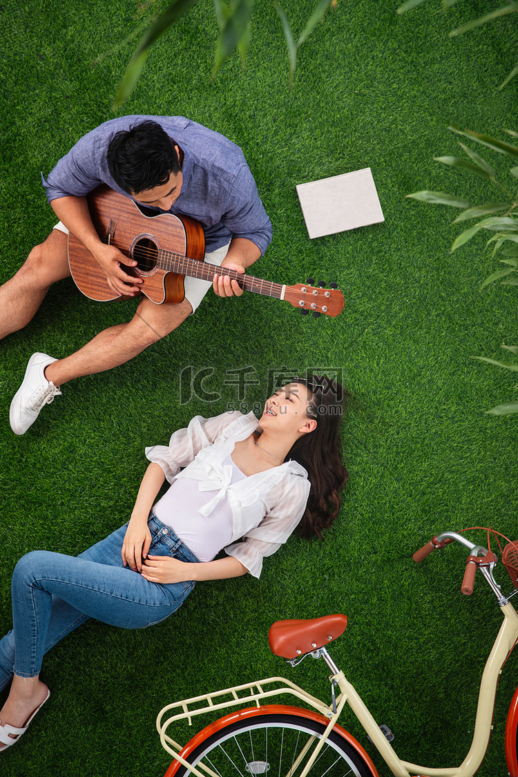 幸福的青年伴侣在草地上享受快乐
