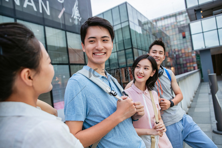 户外快乐的大学生倚栏而站