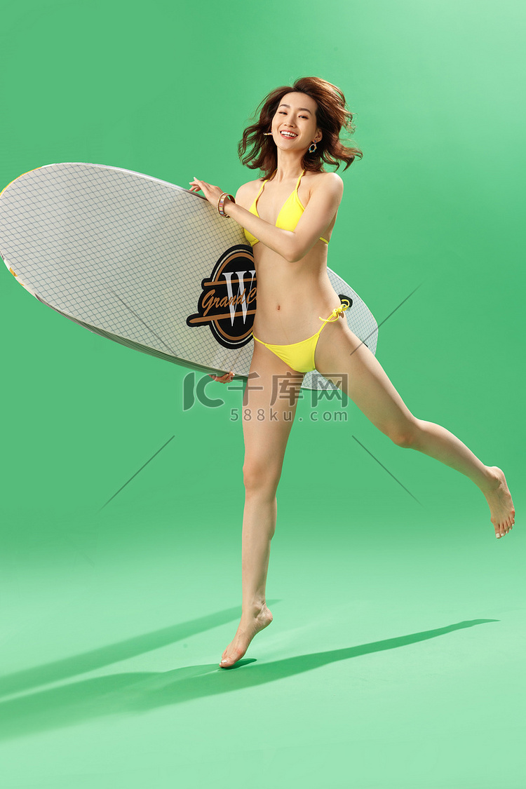 兴奋的青年女人抱着冲浪板