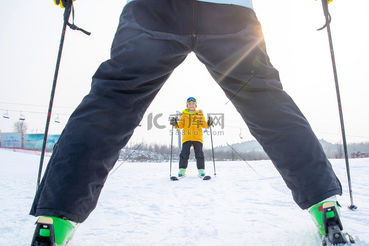 滑雪场上面对面滑雪的快乐父子