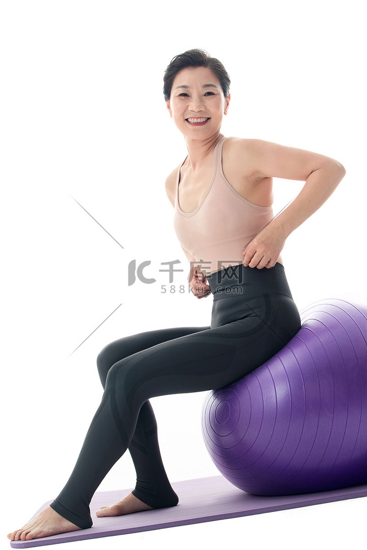 中年女性坐在瑜伽球上