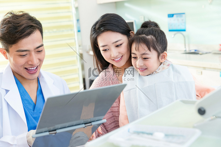 年轻妈妈带着小女孩看牙医