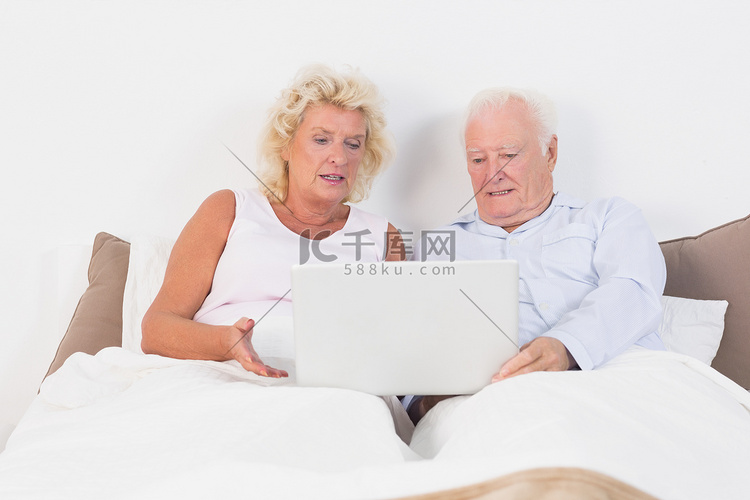 老年夫妇阅读或使用平板电脑