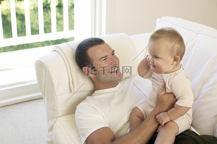 快乐的年轻父亲，有女婴在家沙发