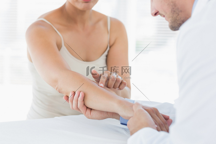 男性理疗师检查女性的手