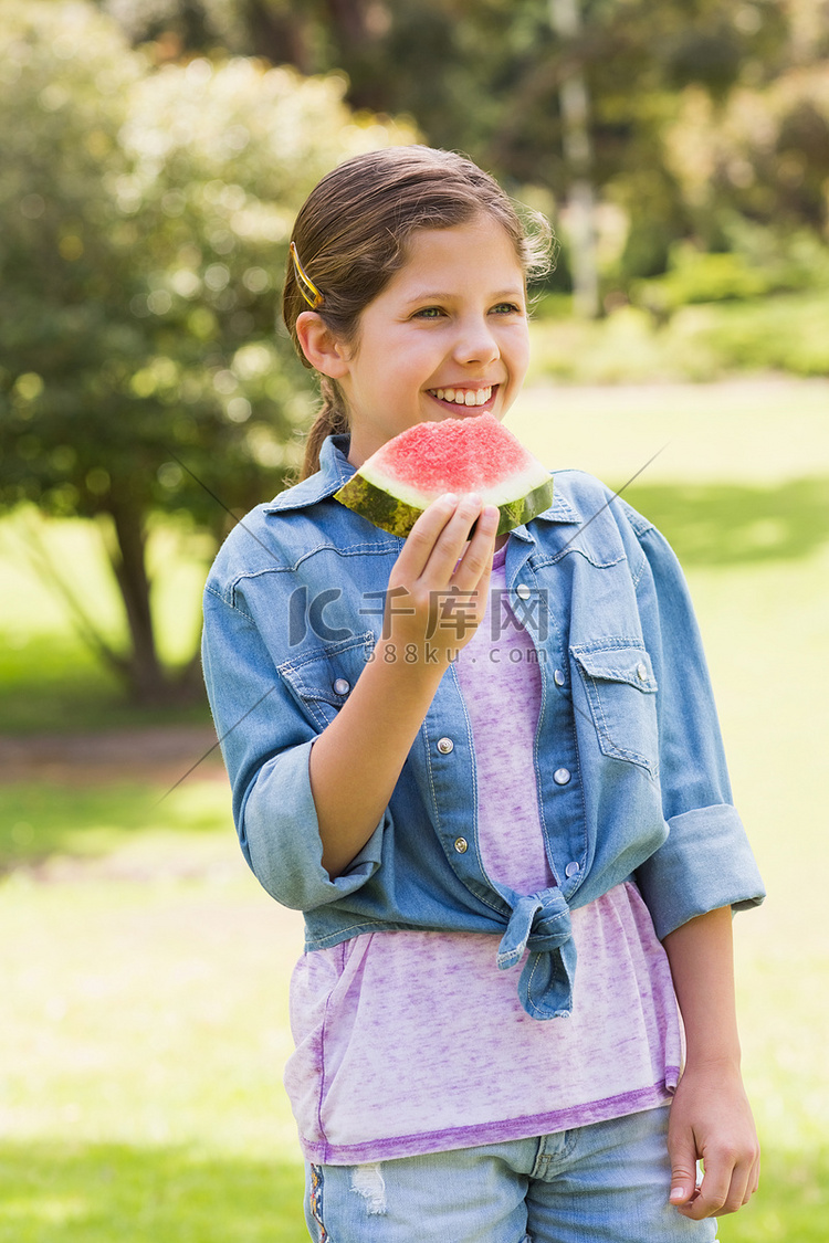 微笑的小女孩在公园吃西瓜