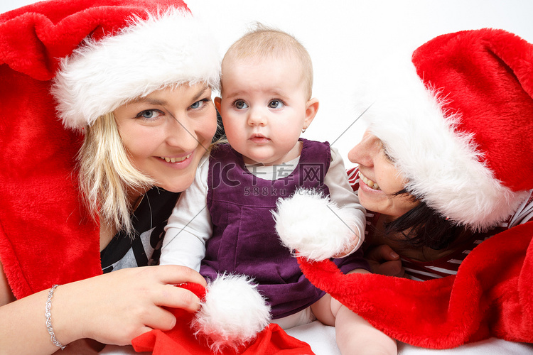 微笑的婴儿和两个戴着圣诞帽的女