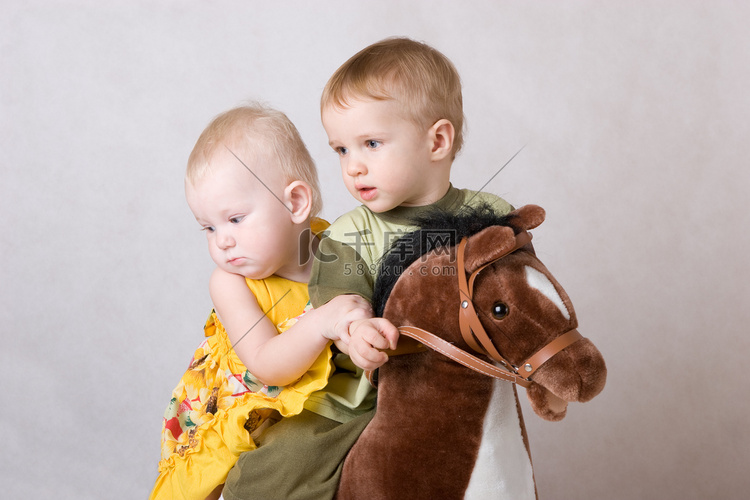 两个孩子在玩玩具马