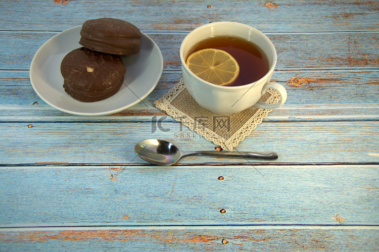 木桌上放着一杯柠檬茶、一把勺子