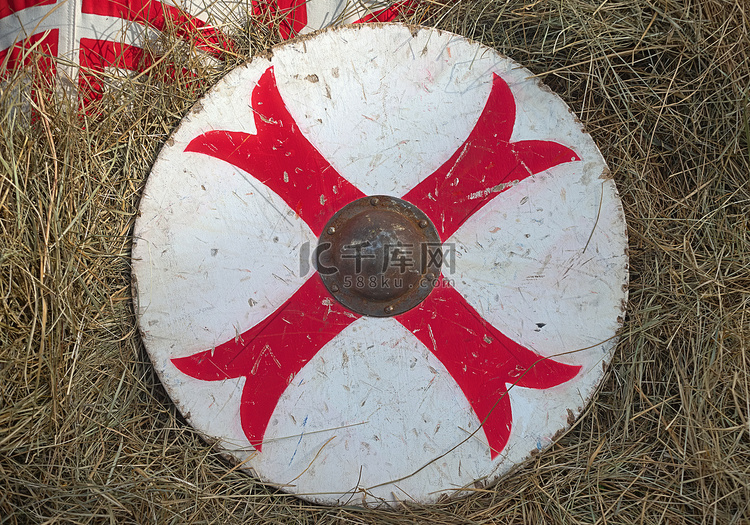 干草上带红十字木盾的中世纪白色