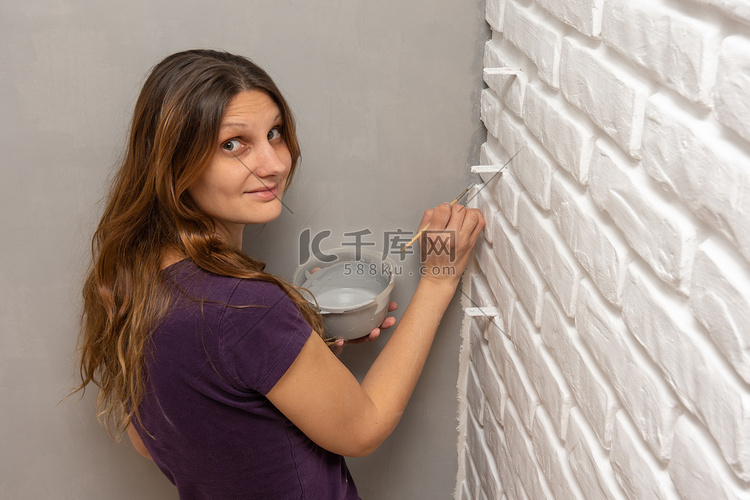 一位房屋油漆工用小流苏在墙壁的
