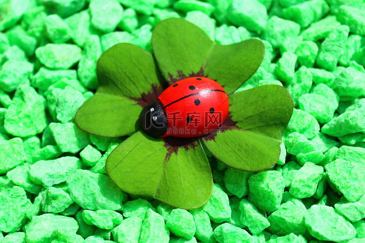 绿色装饰颗粒上的幸运草和瓢虫
