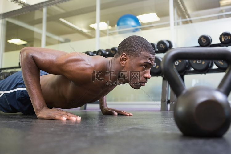 赤膊肌肉男在健身房做俯卧撑