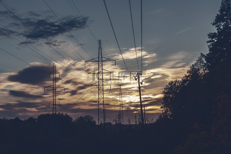 在森林和天空背景的输电线在日落