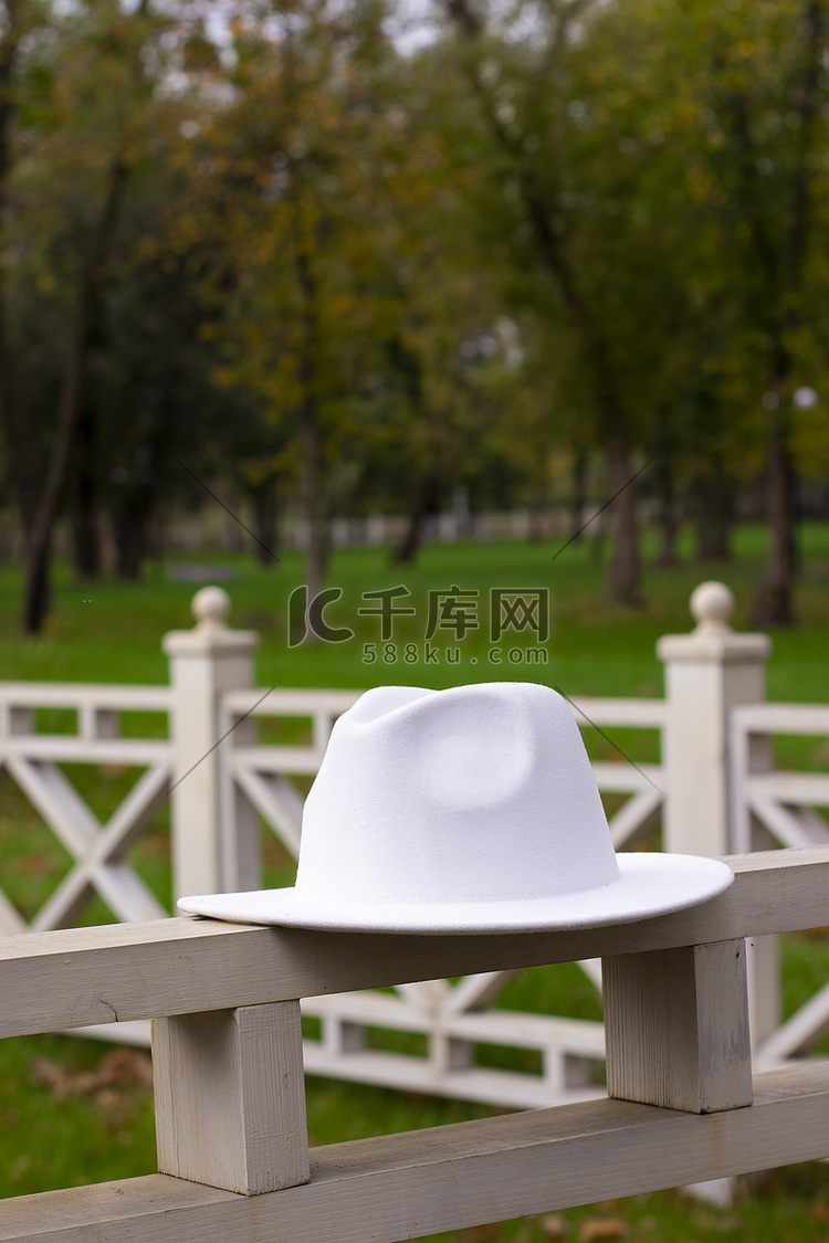 栅栏上的白色时尚男女皆宜的帽子