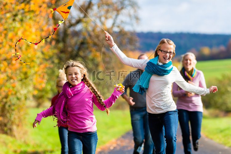 一家人在秋天的森林里散步放风筝