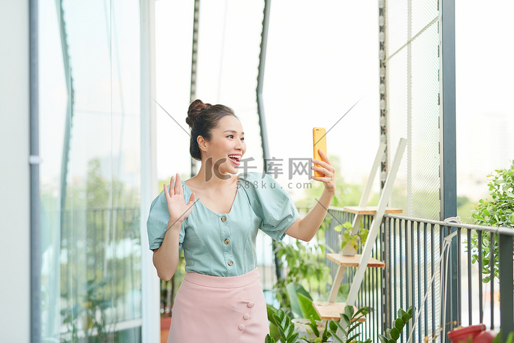 站在阳台上时，快乐的亚洲年轻女